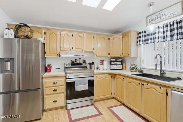 a kitchen with granite countertop a refrigerator oven a sink and cabinets