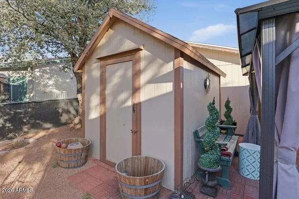 a backyard of a house with potted plants and wooden floor