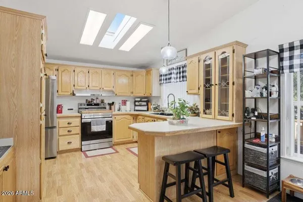 a kitchen with stainless steel appliances kitchen island granite countertop a sink and cabinets