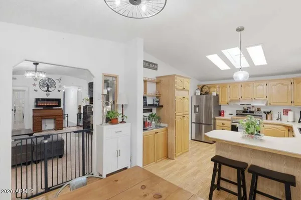 a kitchen with stainless steel appliances kitchen island granite countertop a refrigerator a stove and a sink with wooden floor