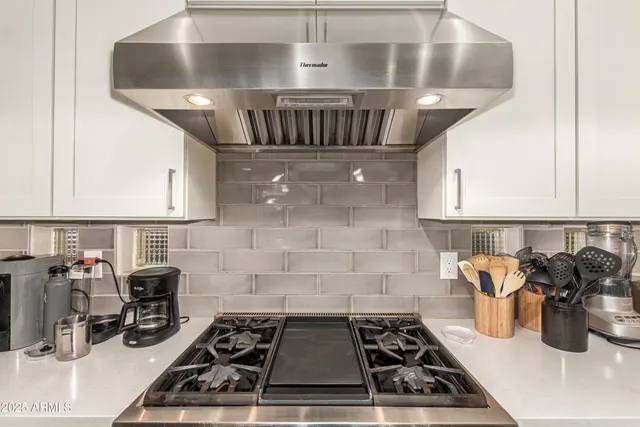 a kitchen with a stove and a white cabinets