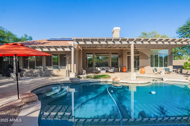 a view of a house with swimming pool and sitting area