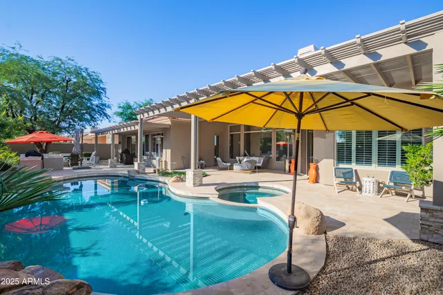 a view of a backyard with swimming pool and furniture