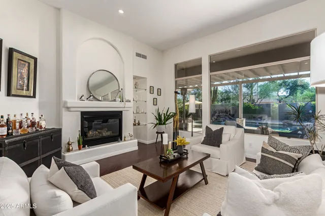 a living room with furniture a fireplace and a floor to ceiling window