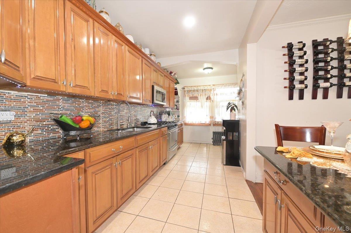130-71 225th Street Queens, NY 11413 - Photo 12 of 26 a kitchen with stainless steel appliances granite countertop a stove a sink and a microwave
