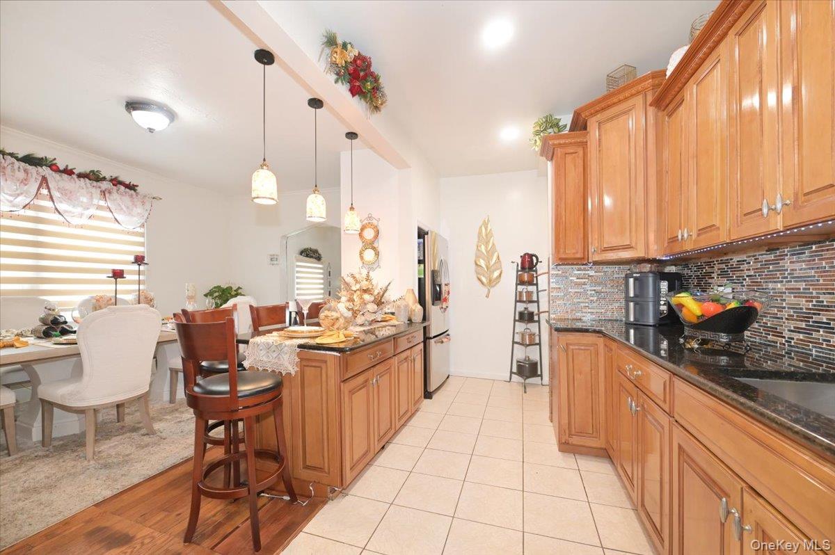 130-71 225th Street Queens, NY 11413 - Photo 13 of 26 a kitchen with stainless steel appliances kitchen island granite countertop a sink and cabinets