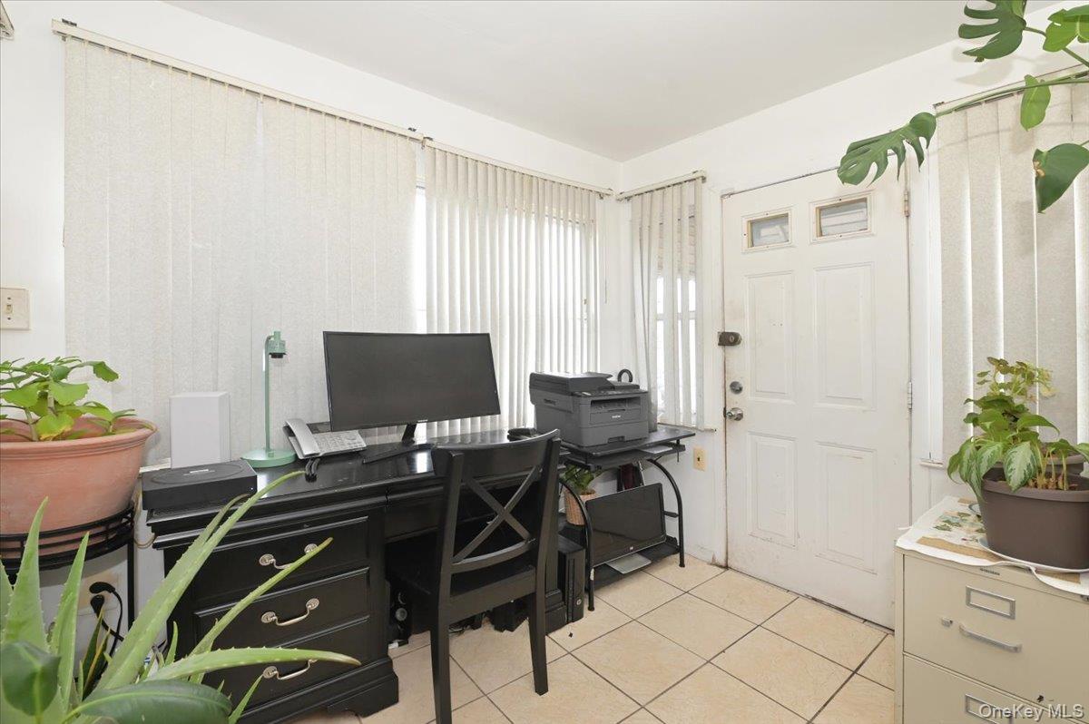 130-71 225th Street Queens, NY 11413 - Photo 14 of 26 a view of a workspace with furniture and a potted plant