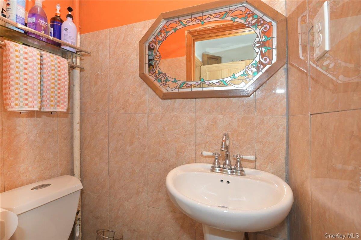 130-71 225th Street Queens, NY 11413 - Photo 15 of 26 a bathroom with a sink and mirror