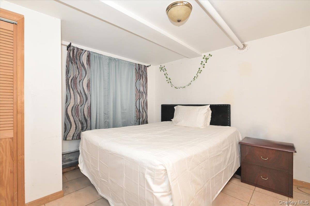 130-71 225th Street Queens, NY 11413 - Photo 22 of 26 a bedroom with a bed and cabinets