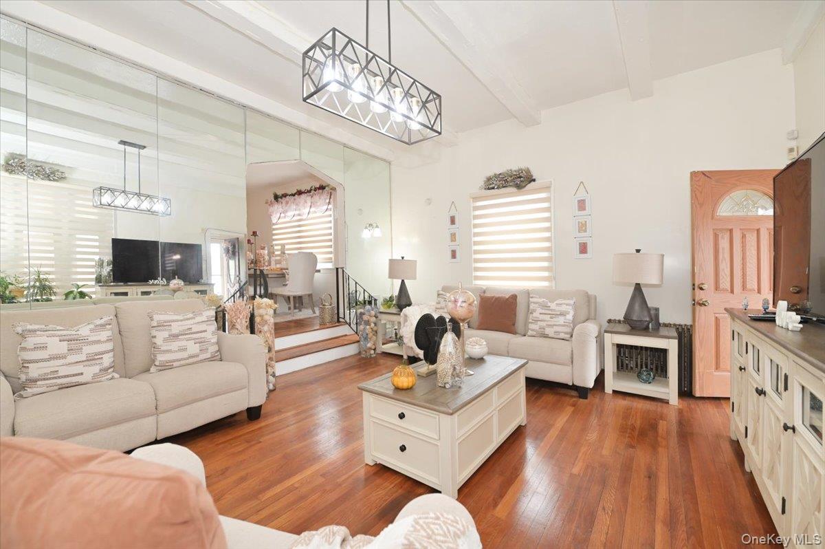 130-71 225th Street Queens, NY 11413 - Photo 4 of 26 a living room with furniture wooden floor and a chandelier