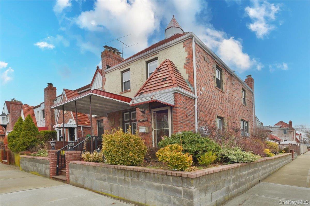 130-71 225th Street Queens, NY 11413 - Photo 7 of 26 a front view of a house with a garden