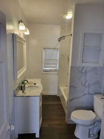 a bathroom with a granite countertop sink toilet and shower