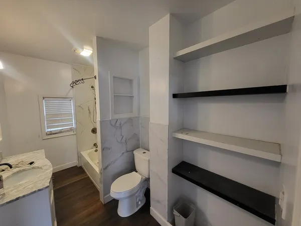 a bathroom with a toilet a sink and shower
