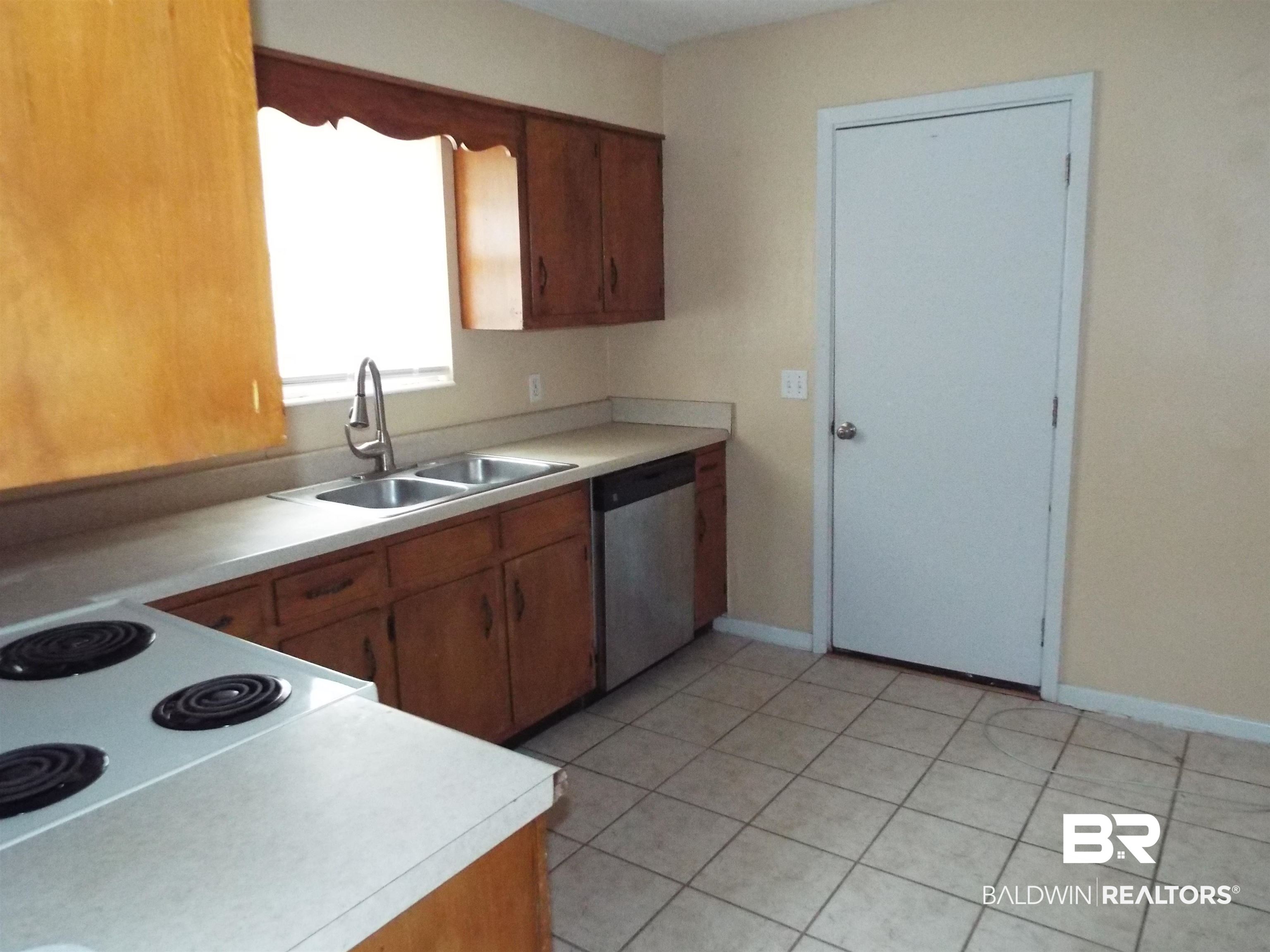 604 Southern Way Spanish Fort, AL 36527 - Photo 3 of 13 Kitchen featuring dishwasher, light tile patterned flooring, and sink