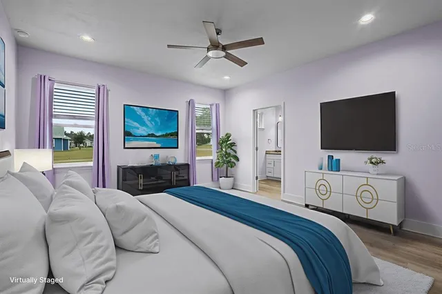 a bedroom with a bed and a flat screen tv on the dresser