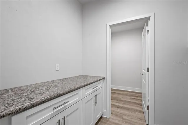 a utility room with granite countertop cabinets and a sink