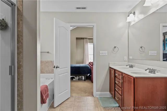 a en suite bathroom with a sink a mirror and a bathtub