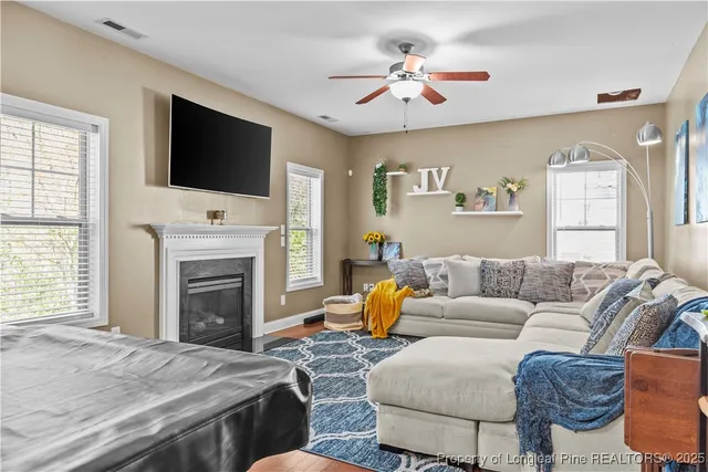 a living room with furniture a flat screen tv and a fireplace