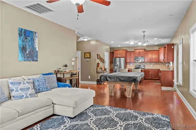 a living room with furniture a rug and kitchen view