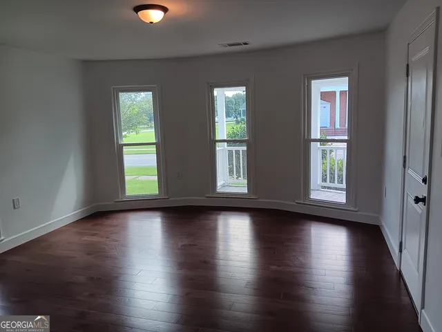 a view of room with window and wooden floor