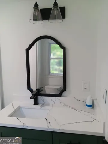 a bathroom with a granite countertop sink and a mirror