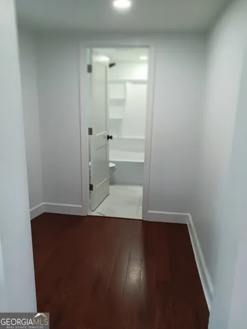 an empty room with wooden floor and mirror