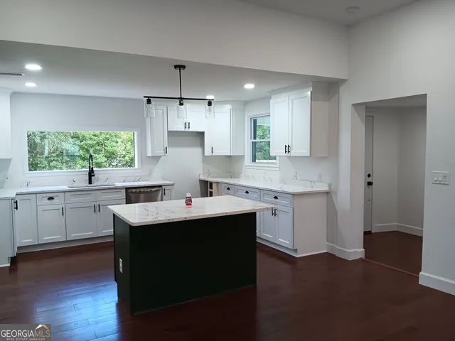 a kitchen with sink cabinets and wooden floor