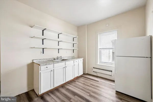 a kitchen with granite countertop white cabinets and white appliances