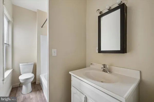 a bathroom with a toilet sink and mirror