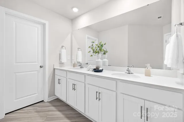 a bathroom with a double vanity sink and mirror