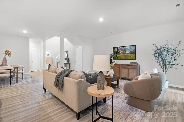 a living room with furniture a dining table and a potted plant