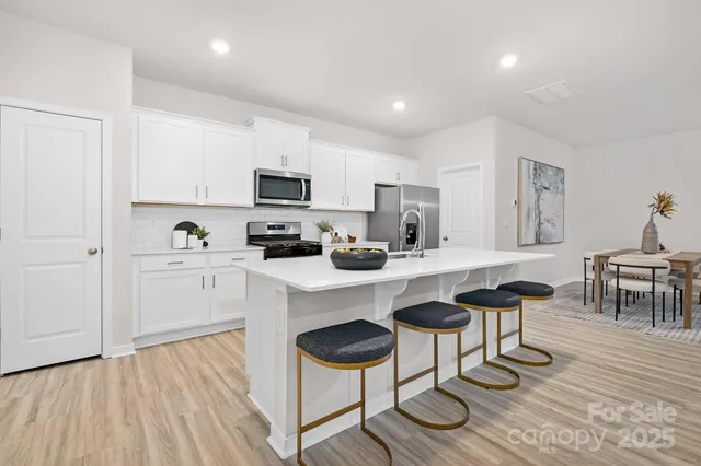 a kitchen with cabinets and chairs