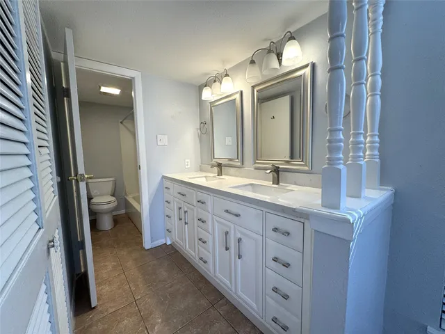 an empty room with chandelier fan and windows