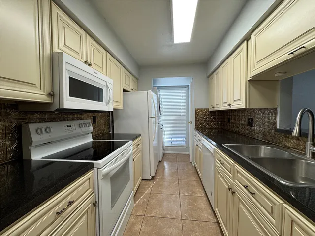 a kitchen with a refrigerator sink and cabinets