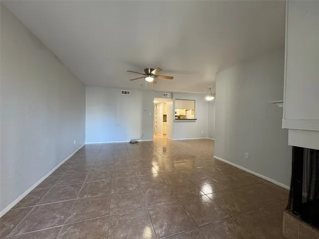 an empty room with windows and fireplace