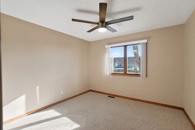 an empty room with a window and a fan