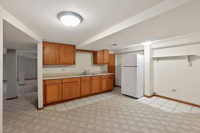 a large kitchen with a refrigerator a sink stainless steel appliances and cabinets