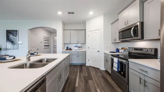 a kitchen with white cabinets and white appliances