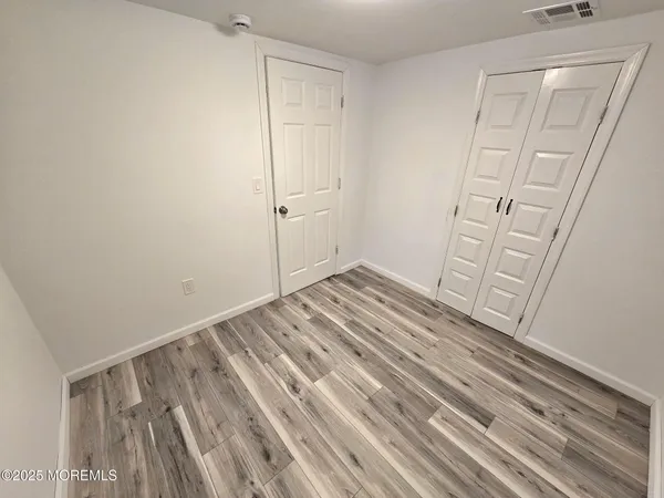 a view of empty room with wooden floor