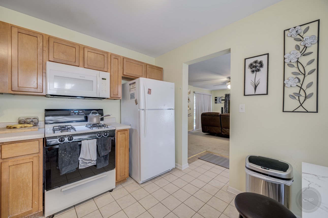 2827 Rutland Circle, Unit 101 Naperville, IL 60564 - Photo 12 of 25 a kitchen with stainless steel appliances granite countertop a refrigerator sink and stove