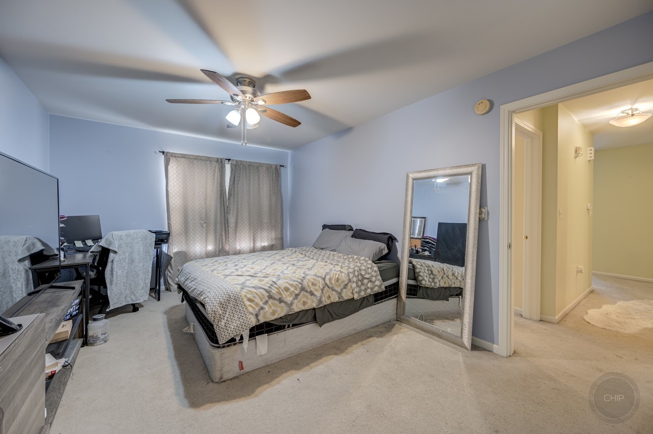 2827 Rutland Circle, Unit 101 Naperville, IL 60564 - Photo 14 of 25 a spacious bedroom with a bed and a chandelier