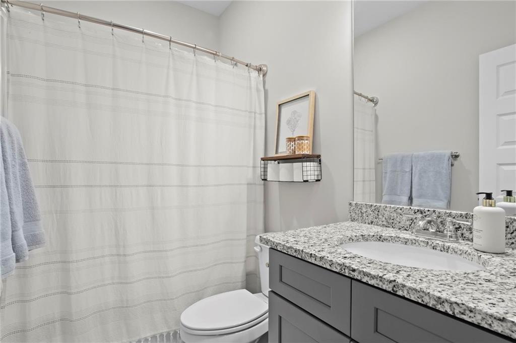 217 Eva Way Cartersville, GA 30121 - Photo 23 of 27 a bathroom with a granite countertop sink a toilet and shower