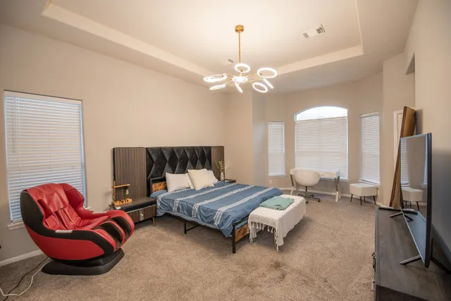 a spacious bedroom with a bed and ceiling fan