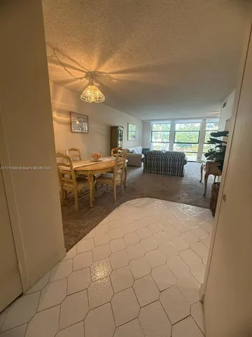 a living room with furniture a chandelier and a dining table