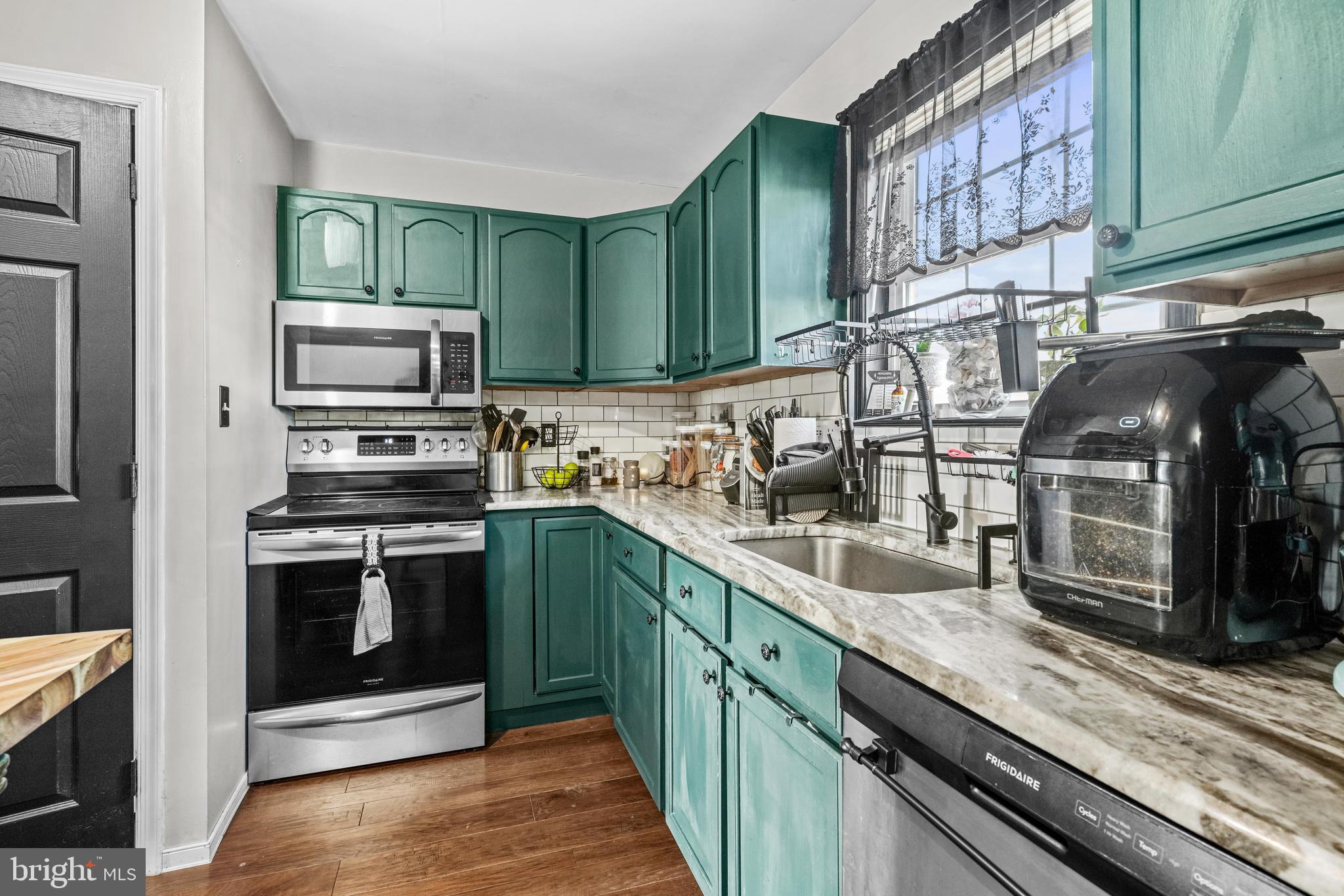 563 Maple Way Lusby, MD 20657 - Photo 11 of 16 a kitchen with stainless steel appliances granite countertop a stove a sink and a microwave