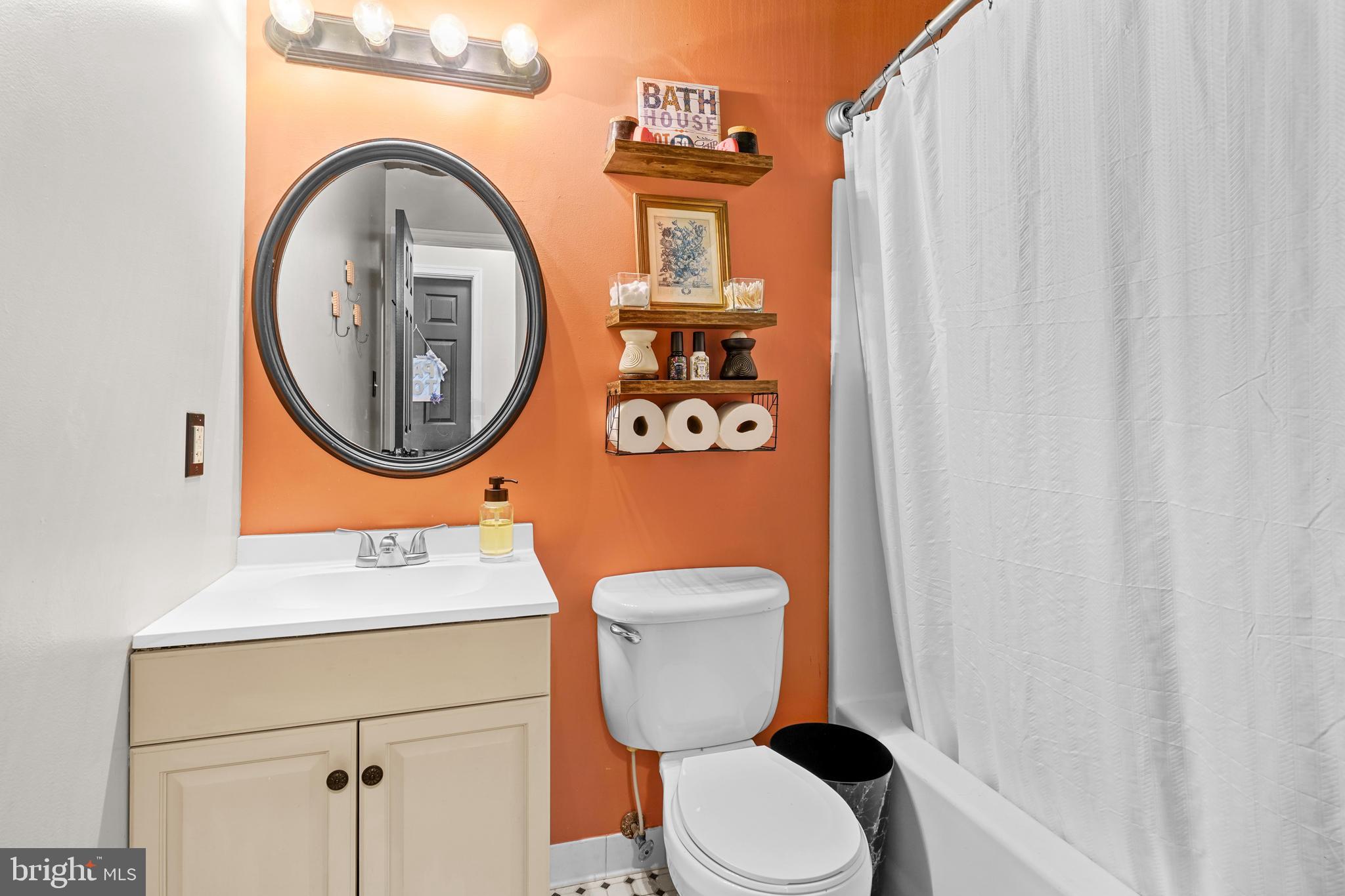 563 Maple Way Lusby, MD 20657 - Photo 5 of 16 a bathroom with a toilet sink vanity and mirror