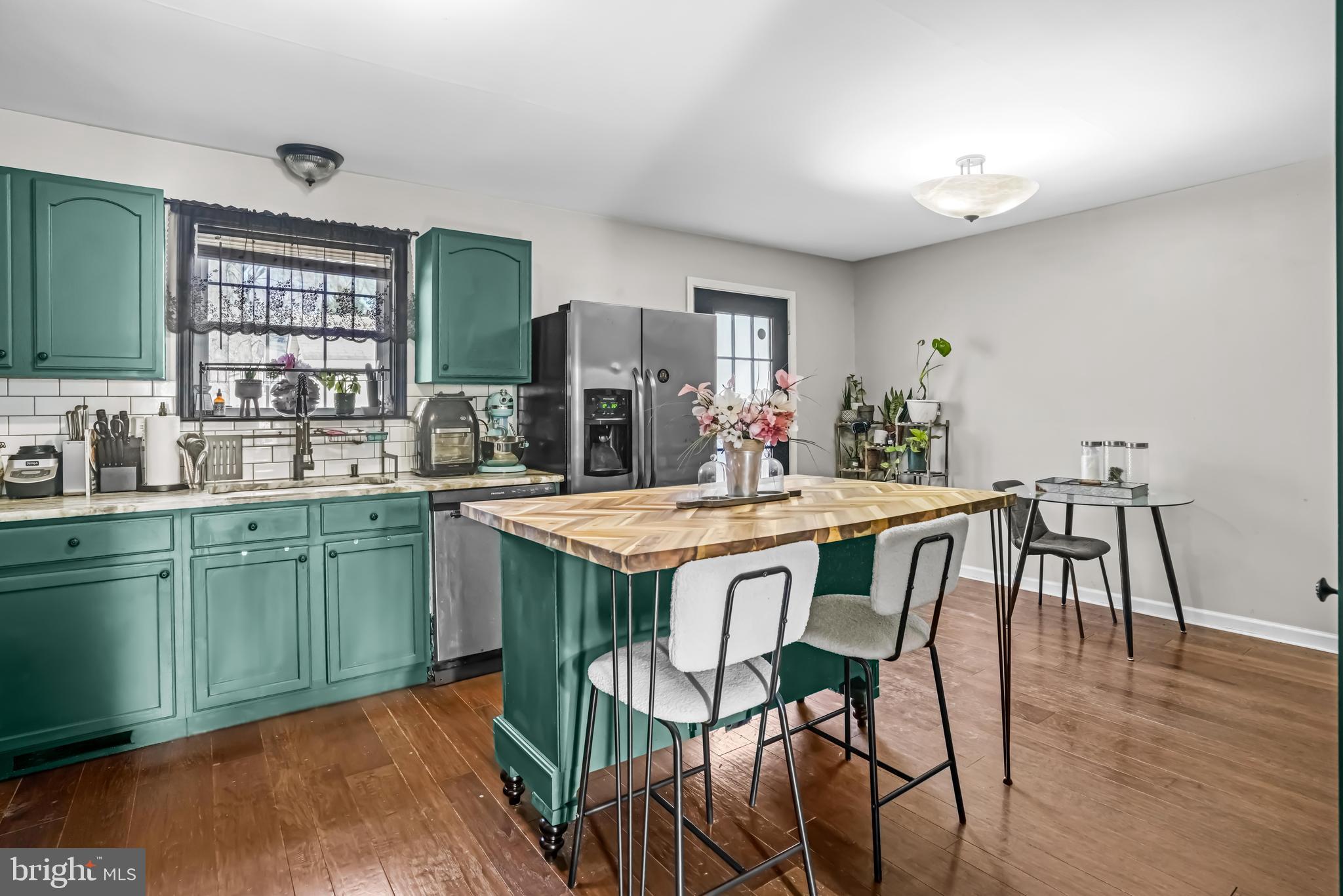 563 Maple Way Lusby, MD 20657 - Photo 8 of 16 a kitchen with granite countertop a table chairs stove and cabinets