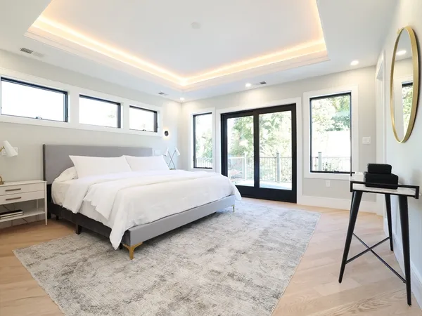 a large white bed sitting in a room next to a window