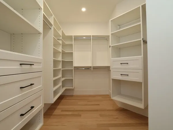 a view of walk in closet with empty racks