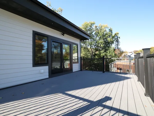a view of a balcony with floor to ceiling windows wooden floor and fence